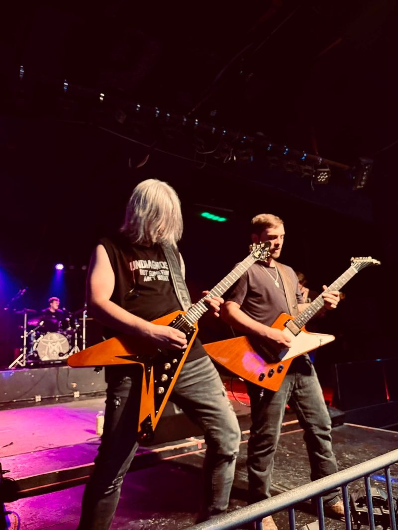 Bloodhound guitarists under the stage lights at a club show